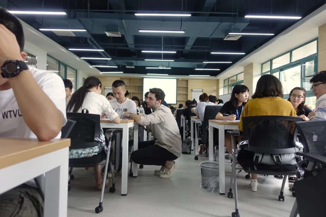 An image of a young man teaching a group of students in a kind way.